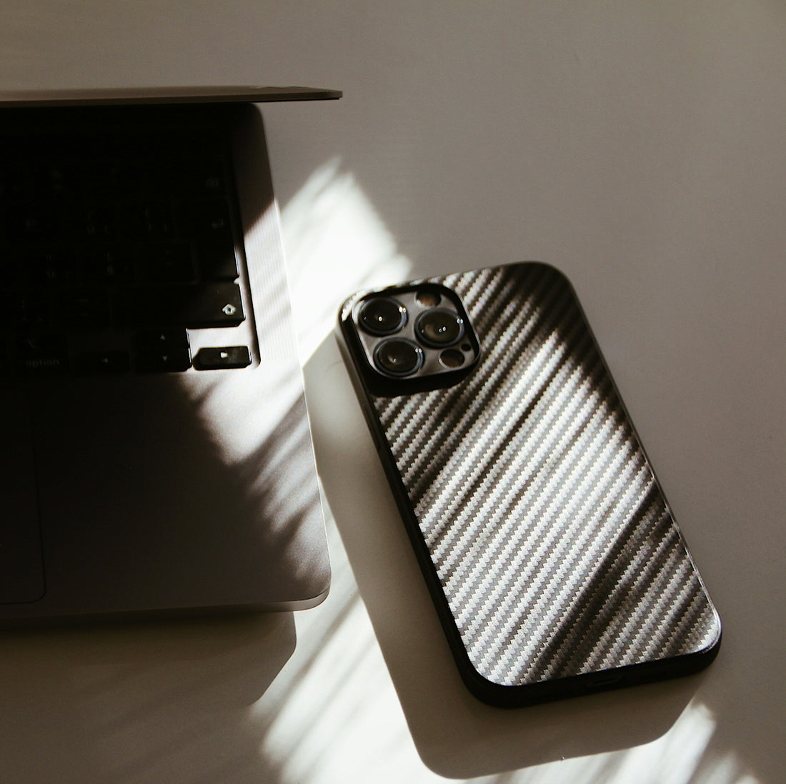 A cell phone sitting on top of a table next to a laptop