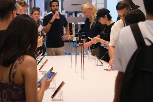 People examining smartphones displayed on a table.