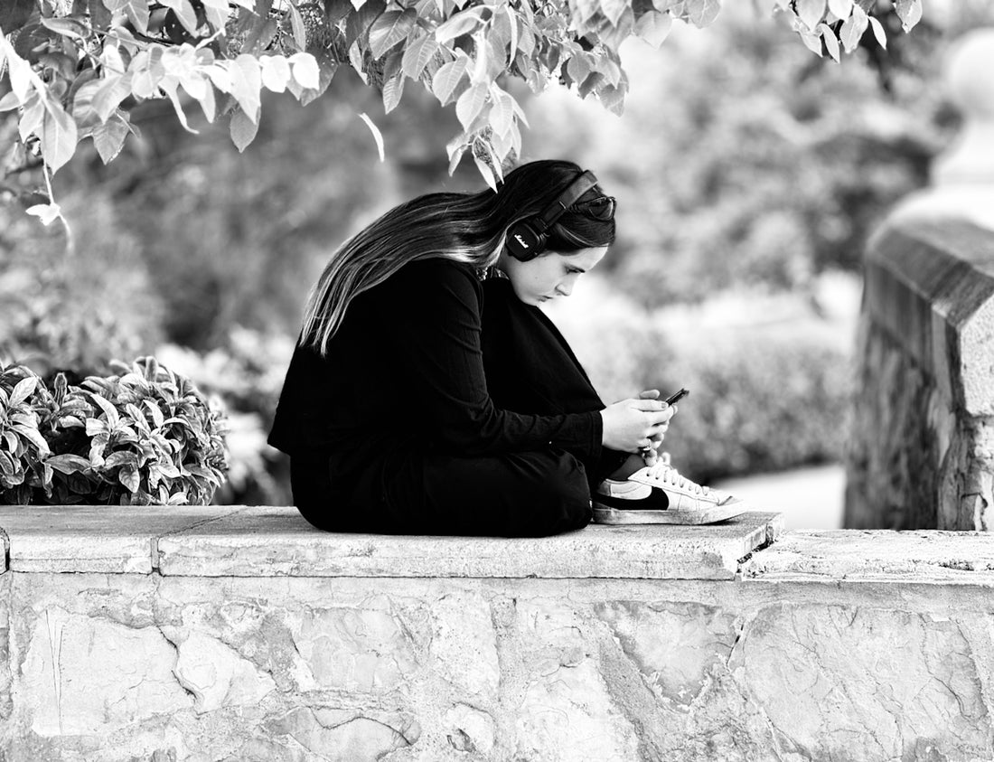 Young woman with headphones using a smartphone outdoors
