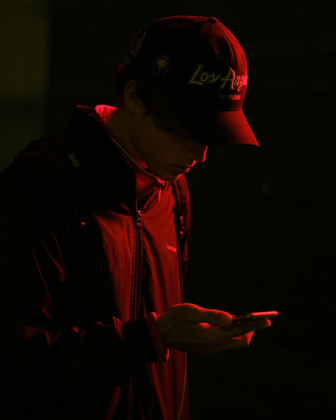 Person in a baseball cap looking at a phone.