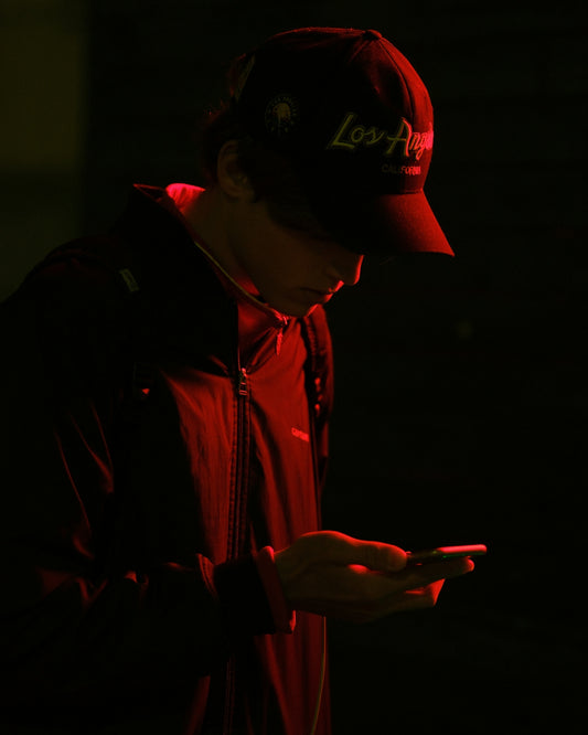 Person in a baseball cap looking at a phone.