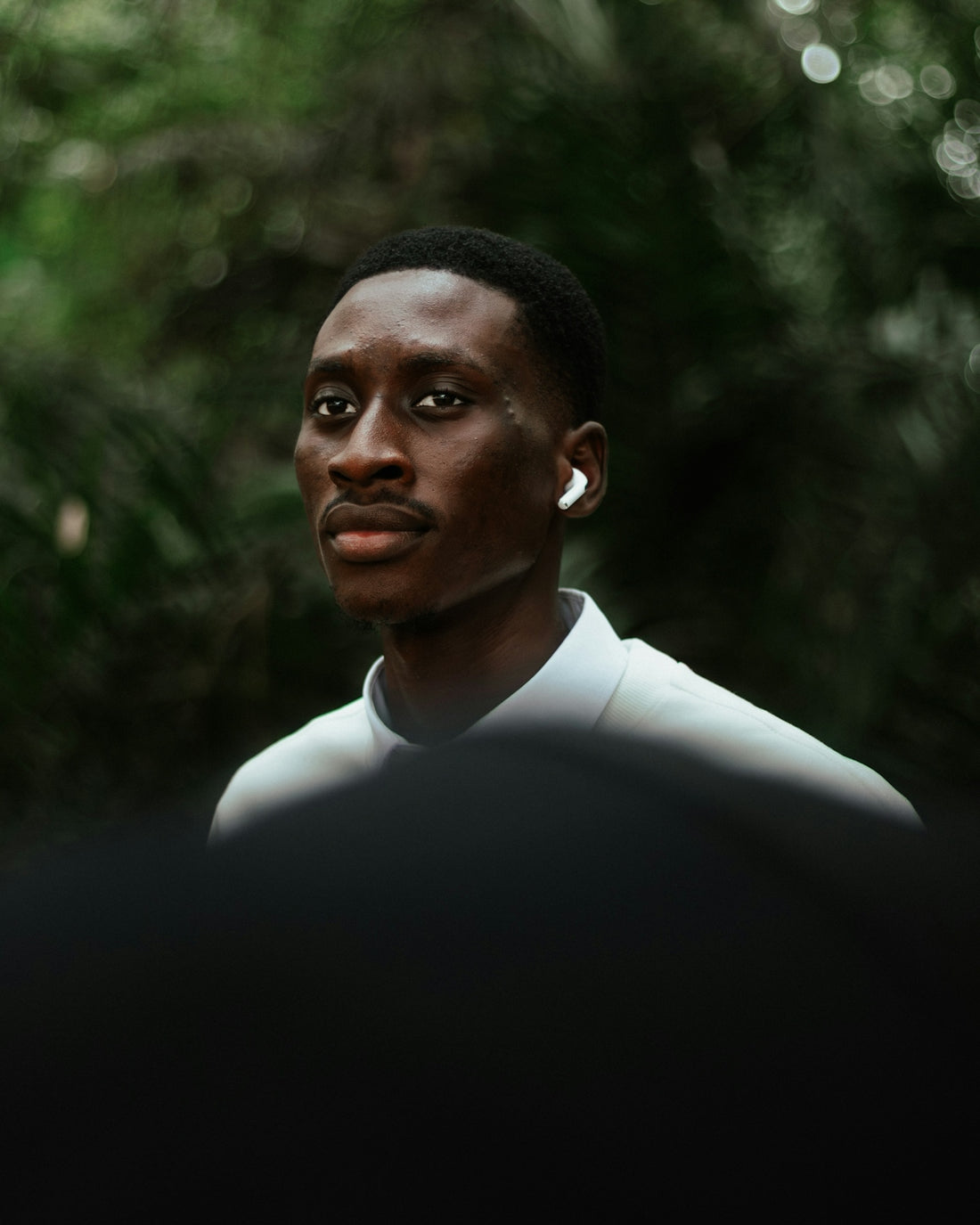 Young black man wearing earbuds outdoors