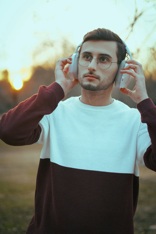 Man wearing headphones outdoors at sunset