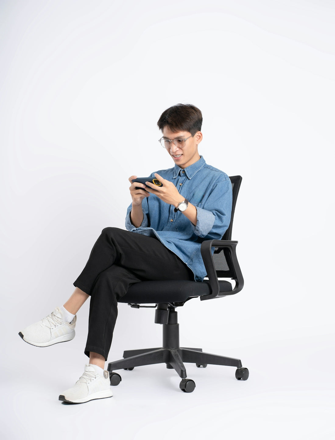 Young man playing video games on a smartphone.