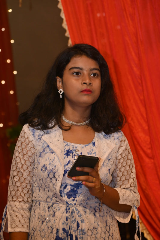 A young woman holding a smartphone indoors.
